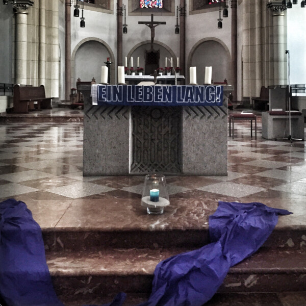 Am Altar der St.-Joseph-Kirche hängt ein blauer Schal mit dem Schriftzug "Ein Leben lang" in weißen Lettern.