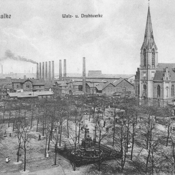 Eine Postkartenansicht in schwarz-weiß zeigt den Schalker Markt um das Jahr 1900. Der Schalker Markt ist mit Bäumen bewachsen. Zwischen ihnen steht der Grillo-Brunnen. Rechts steht die Evangelische Friedenskirche. Im Hintergrund ragen Schornsteine in den Himmel.