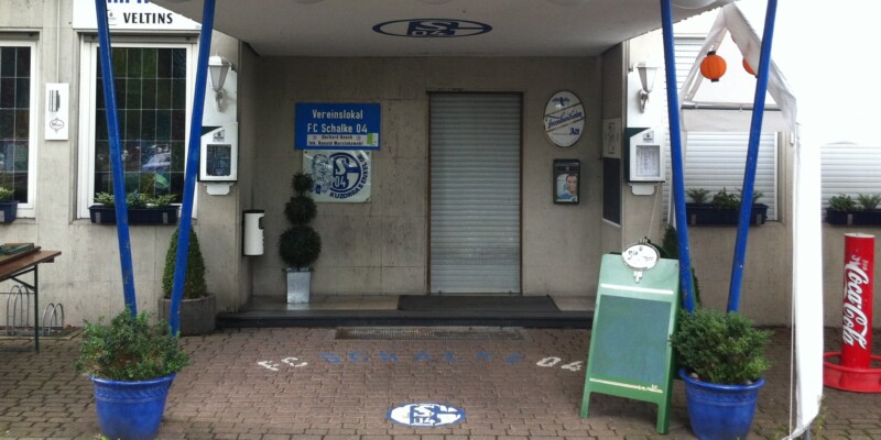 Heute ist der Eingang zum Vereinslokal "Bosch" an der Kampfbahn Glückauf in Schalke überdacht. Auf dem Dach ist über die ganze Breite angebracht. Auf dem Schild steht "FC Schalke 04".