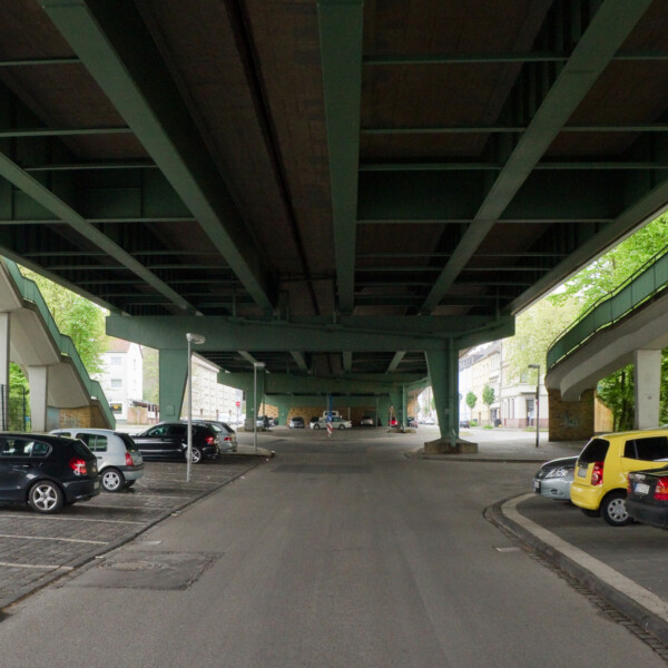 Unteransicht der Berliner Brücke. Unter ihren Stahlträgern liegen Parkplätze.