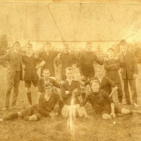 Eine verblichene Fotografie von jungen Fußballspielern. Sie posieren in Sportzeug für ein Mannschaftsfoto.