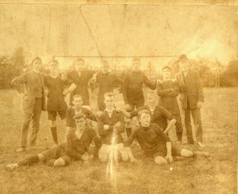 Eine verblichene Fotografie von jungen Fußballspielern. Sie posieren in Sportzeug für ein Mannschaftsfoto.