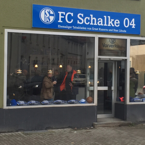 Außenansicht des Tabakladens heute. Über dem Schaufenster hängt ein Schild mit der Aufschrift FC Schalke 04.