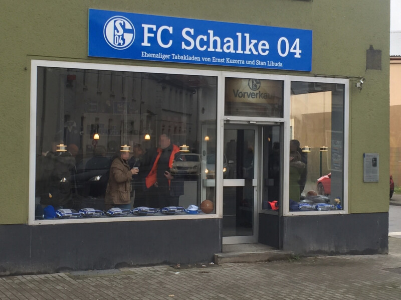 Außenansicht des Tabakladens heute. Über dem Schaufenster hängt ein Schild mit der Aufschrift FC Schalke 04.