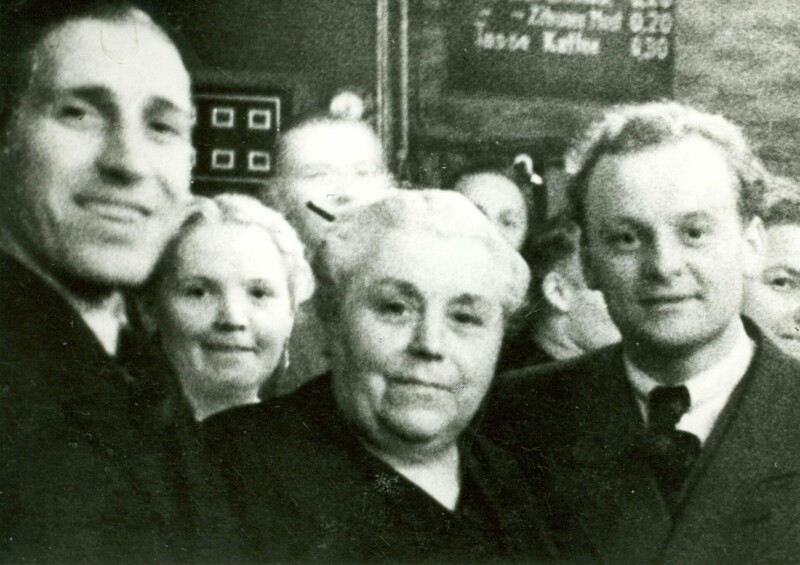 Ernst Kuzorra, Henriette Thiemeyer und Ötte Tibulsky stehen bei einer Meisterfeier des FC Schalke 04 vor der Kaiserhalle am Schalker Markt und schauen in die Kamera.