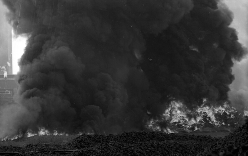 Eine dichte schwarze Rauchwolke füllt das gesamte Bild aus. Darunter sind Flammen zu erkennen.